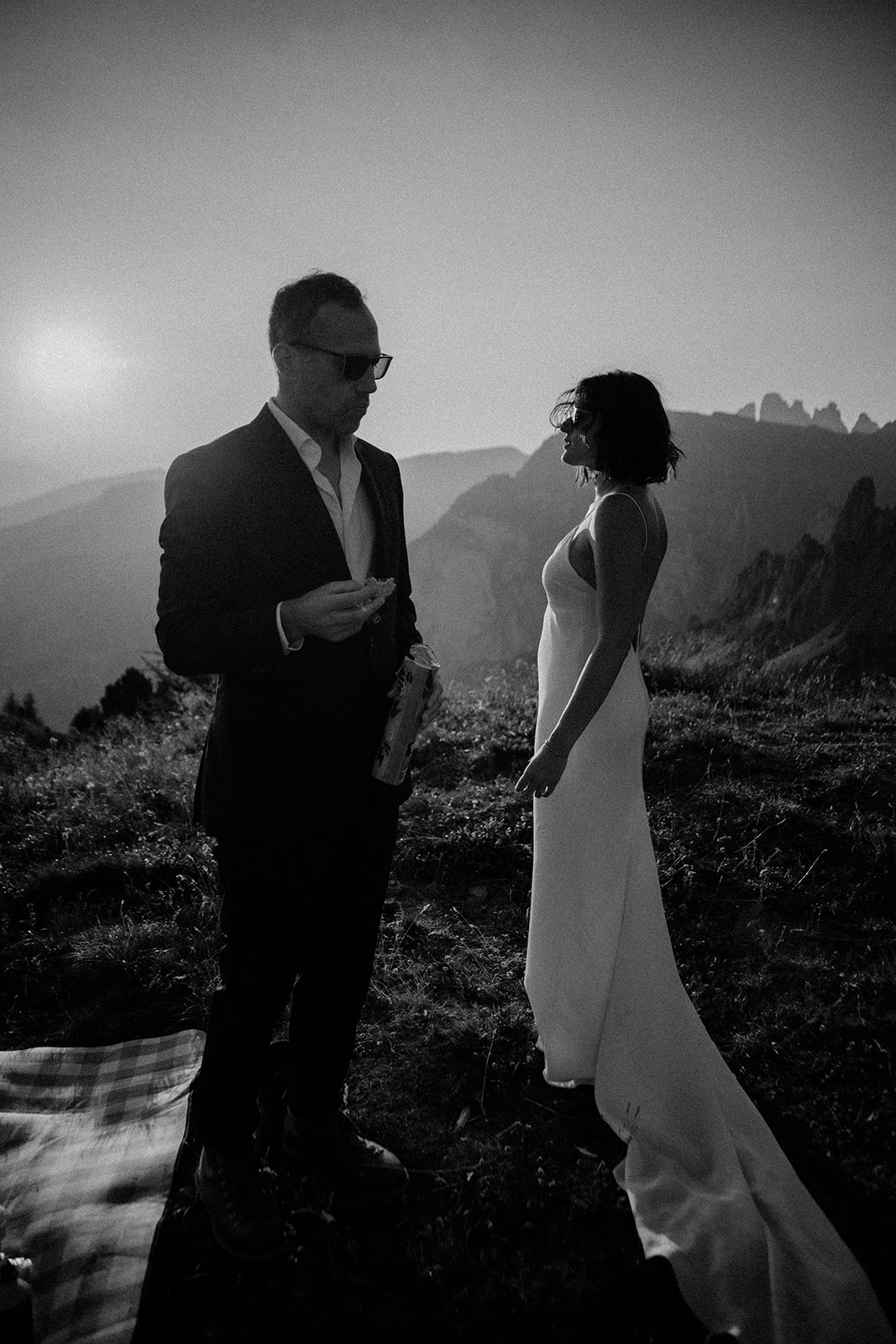 Custom Dolomites Elopement Packages - bride and groom watching sunset and eating cookies in the Dolomites mountains